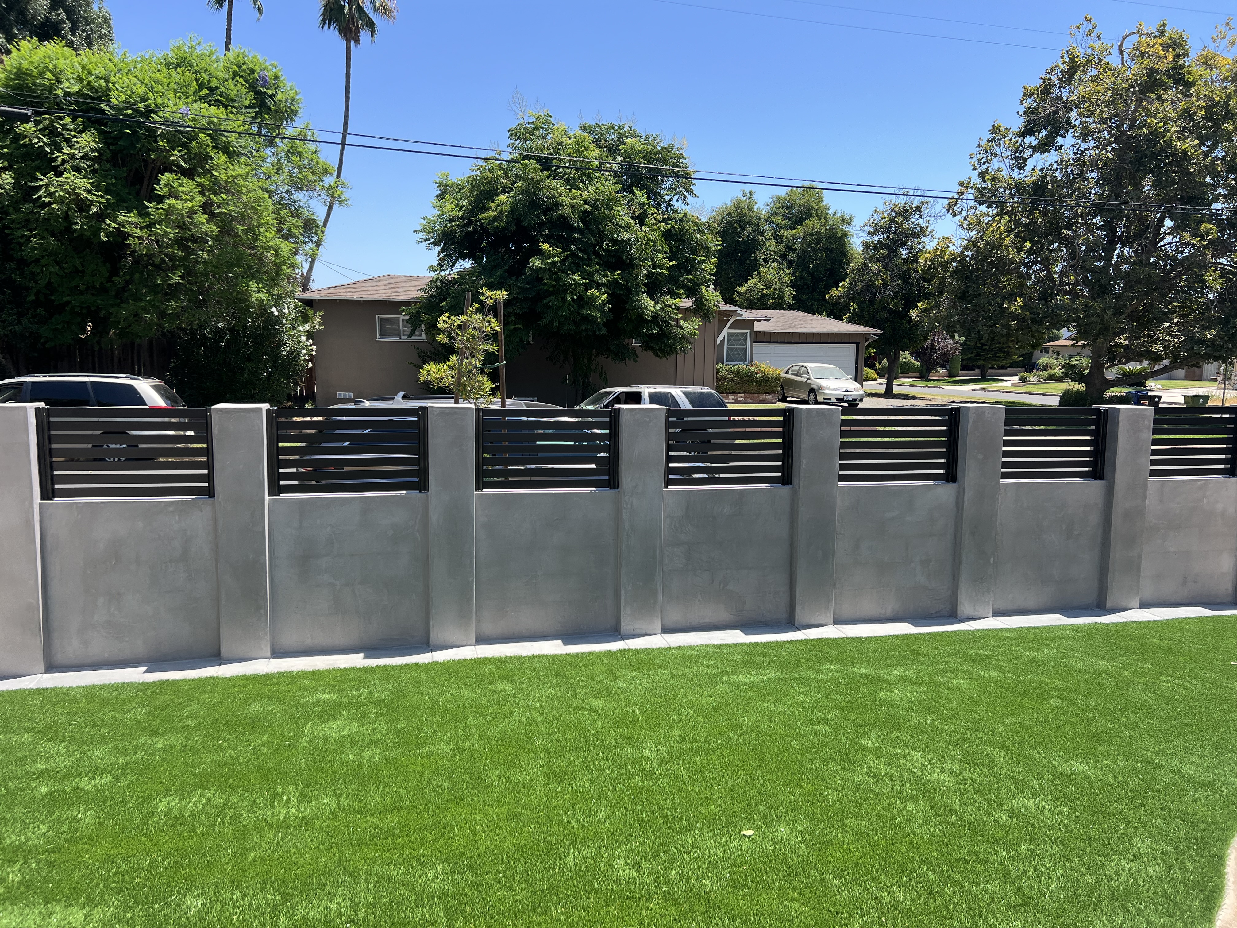 Aluminum horizontal slat fence on concrete block columns — front view
