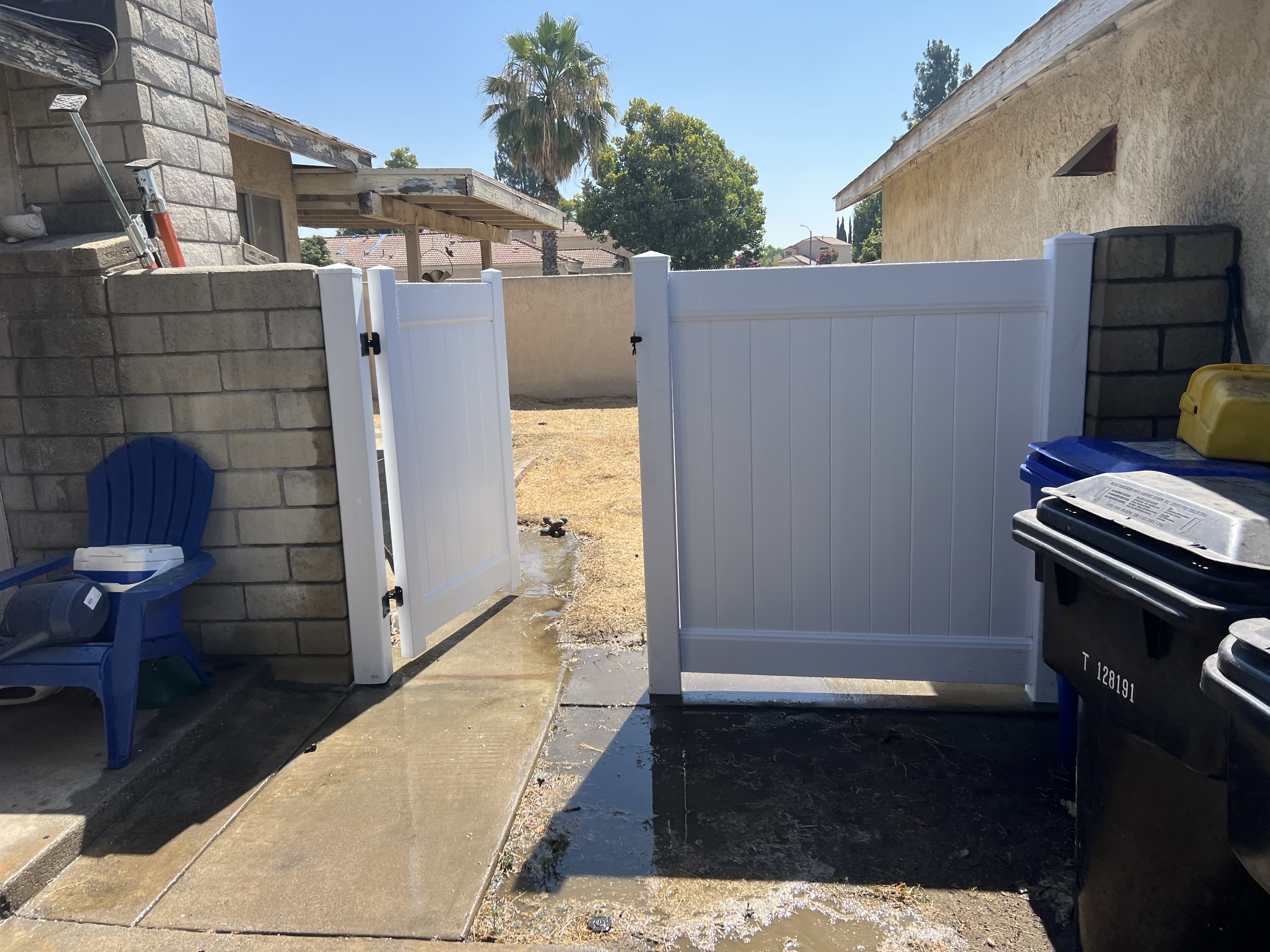 White vinyl fence panel with single walk gate — residential installation